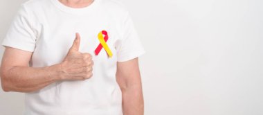 Dünya Hepatit Günü farkındalık ayı, 28 Temmuz. Kırmızı ve sarı kurdeleli yaşlı kadın. Karaciğer kanseri, sarılık, siroz, başarısızlık, büyüme, Hepatik Ensefalopati ve Sağlık Konsepti