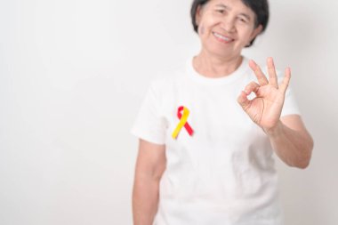 Dünya Hepatit Günü farkındalık ayı, 28 Temmuz. Kırmızı ve sarı kurdeleli yaşlı kadın. Karaciğer kanseri, sarılık, siroz, başarısızlık, büyüme, Hepatik Ensefalopati ve Sağlık Konsepti