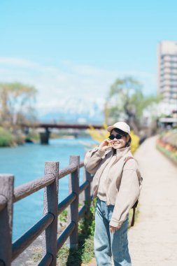 Iwate Dağı 'nı gezen kadın ve baharda çiçekli Kitakami nehri, Morioka şehrinde seyahat eden mutlu gezgin, Iwate Bölgesi, Japonya. Ünlü Landmark Seyahat ve Tatil Yeri