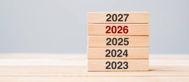 2027 blok 2026 ve 2025 ahşap bina masa arkasında. İş planlaması, Risk Yönetimi, Çözüm, Strateji, Çözüm, Hedef, Yeni Yıl Yeni Sen ve Mutlu Noeller kavramları