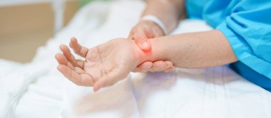 Hastanede bilek ağrısı çeken yaşlı bir kadın, Karpal Tünel Sendromu nedeniyle kas ağrısı, De Quervain 's tenosynovitis, romatoid, artrit, gut, Parkinson hastalığı ve ergonomik sağlık hizmetleri 