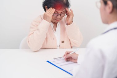 Kıdemli kadın baş ağrısı çekiyor ve bir hastalığa danışmanlık yapıyor. Yaşlı sağlık hastası, Tıbbi Teşhis, Migren, Beyin Tümörü, Beyin Felci, Bunama, Nörolojik Bozukluk, Alzheimer, Parkinson