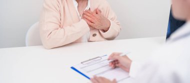 Yaşlı hasta kadın göğüs ağrısı çekiyor ve danışman doktor. Kalp hastalığı, anjin hastalığı ve semptom kalp krizi hastalığı kardiyovasküler, atheroskleroz, hipertansif, dünya kalp günü ve sağlık