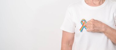 Haziran Gurur Ayı, Nisan Otizm Bilinci, Kanser Farkındalığı, Şubat Dünya Kanser Günü, Ekim Dünya Bakımevi ve Palyatif Bakım Günü konsepti için LGBTQ Gökkuşağı kurdelesine sahip yaşlılar