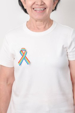 Haziran Gurur Ayı, Nisan Otizm Bilinci, Kanser Farkındalığı, Şubat Dünya Kanser Günü, Ekim Dünya Bakımevi ve Palyatif Bakım Günü konsepti için LGBTQ Gökkuşağı kurdelesine sahip yaşlılar