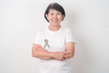 Haziran Gurur Ayı, Nisan Otizm Bilinci, Kanser Farkındalığı, Şubat Dünya Kanser Günü, Ekim Dünya Bakımevi ve Palyatif Bakım Günü konsepti için LGBTQ Gökkuşağı kurdelesine sahip yaşlılar