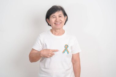 Haziran Gurur Ayı, Nisan Otizm Bilinci, Kanser Farkındalığı, Şubat Dünya Kanser Günü, Ekim Dünya Bakımevi ve Palyatif Bakım Günü konsepti için LGBTQ Gökkuşağı kurdelesine sahip yaşlılar