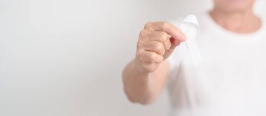 Konsept için beyaz kurdeleli yaşlılar Kasım Akciğer Kanseri Bilinci Ayı, Kadınlara Karşı Şiddeti Durdurma, Evlat Edinme, Mayıs Retinoblastoma, Kadın Sağlığı Eylemi, Mart Osteoporozu, Ekim Osteoporoz 