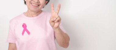 Pembe Ekim Göğüs Kanseri Bilinci ayı için kurdelesi olan yaşlı bir kadın, Mayıs Kadın Sağlığı, Şubat Dünya Kanser Günü, insanlara yaşam ve hastalık desteği veriyor. Ulusal kanser kurtulanları ayı