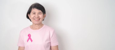 Pembe Ekim Göğüs Kanseri Bilinci ayı için kurdelesi olan yaşlı bir kadın, Mayıs Kadın Sağlığı, Şubat Dünya Kanser Günü, insanlara yaşam ve hastalık desteği veriyor. Ulusal kanser kurtulanları ayı