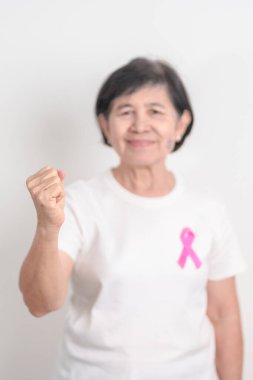 Pembe Ekim Göğüs Kanseri Bilinci ayı için kurdelesi olan yaşlı bir kadın, Mayıs Kadın Sağlığı, Şubat Dünya Kanser Günü, insanlara yaşam ve hastalık desteği veriyor. Ulusal kanser kurtulanları ayı