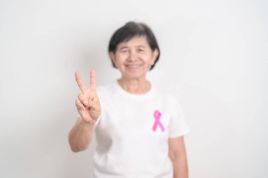 Pembe Ekim Göğüs Kanseri Bilinci ayı için kurdelesi olan yaşlı bir kadın, Mayıs Kadın Sağlığı, Şubat Dünya Kanser Günü, insanlara yaşam ve hastalık desteği veriyor. Ulusal kanser kurtulanları ayı