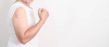 Aşı olduktan sonra bandajlı yaşlı kadın. Grip aşısı, Herpes Zoster, Tetanos, Covid 19 destekleyici, Dang, Ensefalit, Kuduz, Pnömokok, IPD, RSV aşıları 