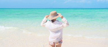 Şapkalı ve plajda eğlenen mutlu kadın turist, tropikal adada güzel deniz manzaralı genç yalnız gezgin. Güneydoğu Asya 'ya seyahat, tatil ve tatil 