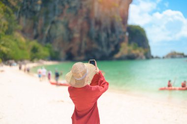 Kadın turist seyahati ve Tayland, Krabi 'yi gezmek. Mutlu gezgin, Railay Sahili yakınlarındaki Phra nang Mağara Sahili 'nin sahillerinde iyi eğlenceler. Yaz gezisi, varış yeri, Güneydoğu Asya Seyahat ve tatil konsepti 