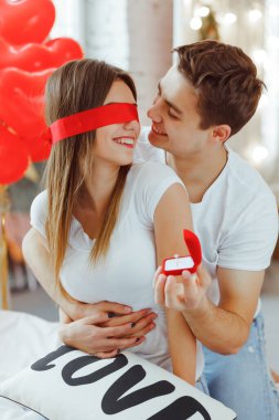 Yakışıklı bir adam, evde güzel bir kadına evlenme teklif ediyor. Erkek, sürpriz yapmak için kadının gözlerini bağlar. Sevgililer Günü için hediye. Kadınlar Günü.
