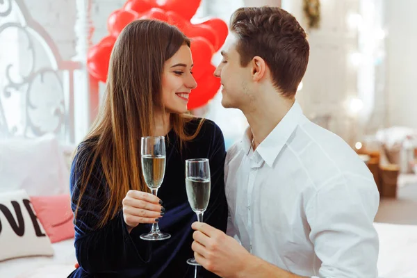Couple in love celebrating Saint Valentine\'s day. They hugging, smiling and drinking champagne. Concept of happy Valentine\'s day. Women\'s day.
