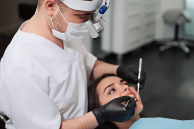 Diş sağlığı önlemesine genel bakış. Diş tedavisi sırasında dişçi koltuğundaki kız. Sağlıklı Gülümse.