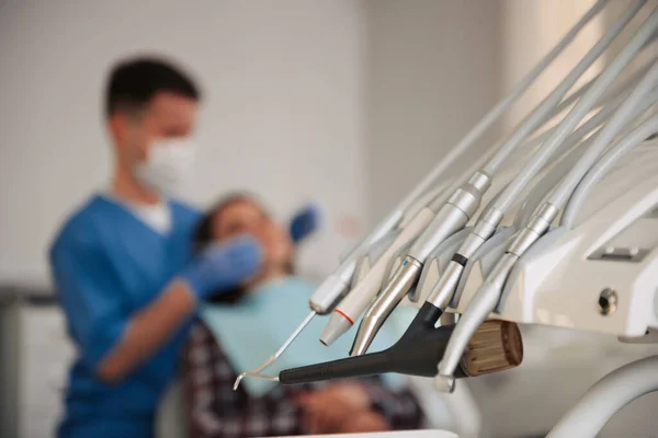 Dental tools with dentist and patient on background.Dental treatment. Modern dental office.