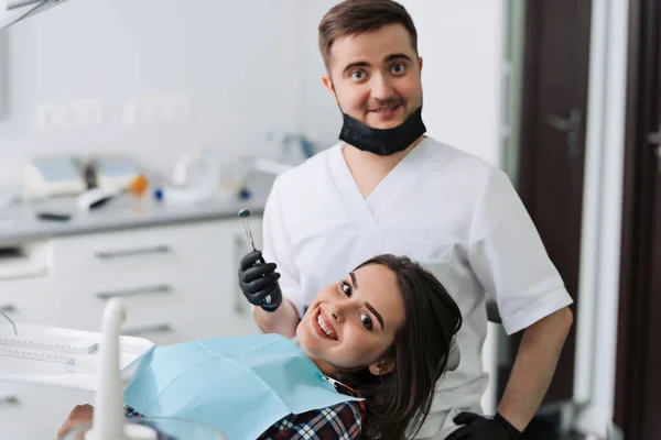 The girl is at the reception at the dentist. A happy client at the dentist smiles. Dental bleaching. Dental clinic. Treatment of teeth in a modern clinic.