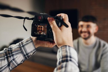 A photographer takes a picture of a man smiling at the camera. Concept of emotions, sincerity.
