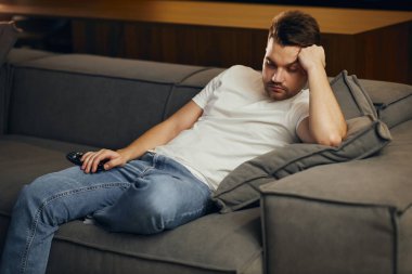 Adam evde kanepenin üzerinde çalışma saatleri içinde yalan Tv. Lazy freelancer izlerken uyuya.