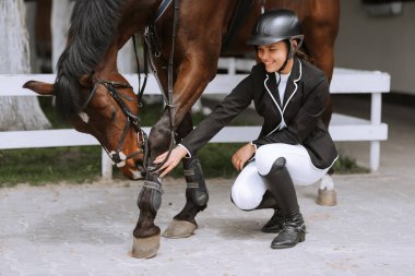 At binicisi istikrarlı, dizgin hazırlanıyor. Genç güzel kız onun at binme önce hazırlanıyor. İnsanlar ve Binicilik kavramı.