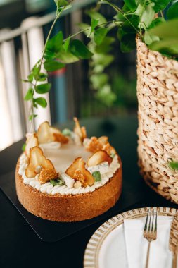 Cheesecake with pear and blue cheese, an incomparable combination of flavors. Beautiful decor with greenery.