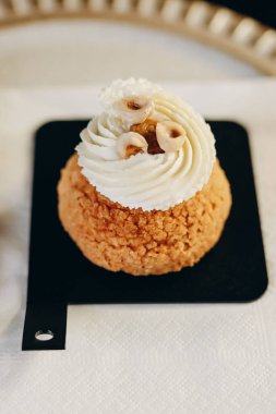 Shu cake decorated with fresh hazelnuts and cream cheese.