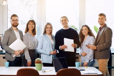 Business workers smiling at the camera.