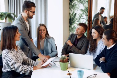 Team of office workers having a teem conversation about business.