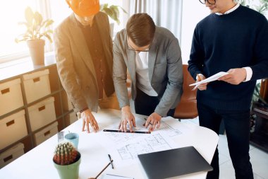 Construction workers talking about future work in the office.