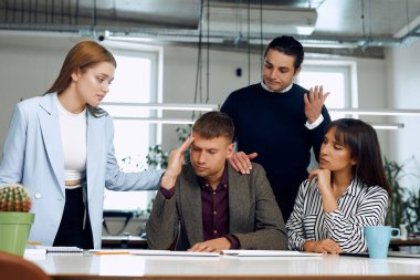 Upset office workers talking after the failed deal.