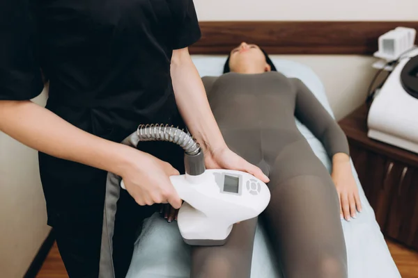 Beautician doing a beautiful figure for a woman, using the LPG apparatus.