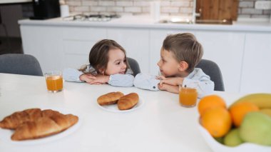 Neşe. Gülümseyen ve kardeşi onlar kahvaltı bakarak oldukça ilham küçük esmer kız