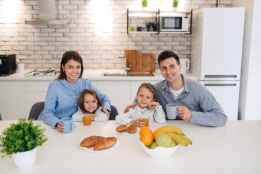 Happy family having breakfast at home. Having healthy breakfast on modern stylish kitchen