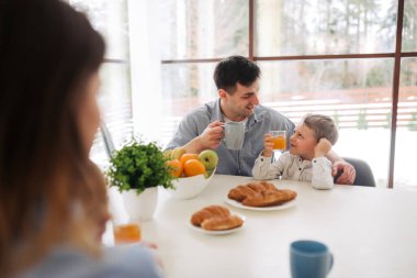 I love you, dad! Handsome young man at home with his little son are having breakfast. Happy Father's Day
