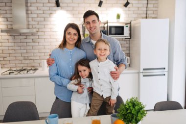 Evde gülümseyen mutlu bir ailenin portresi.