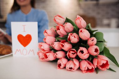 I love my mom! Attractive young woman with flowers at home. Happy family concept. Mother's day