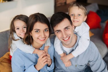 Family relaxing on sofa, hugging and enjoy spending time together at home. Family day concept