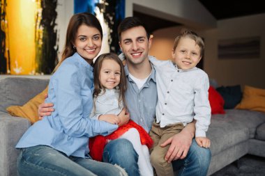 Mutlu bir aile evdeki kanepede oturuyor..