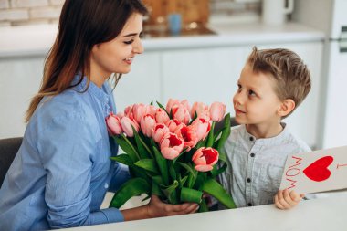 I love my mom! Cute son congratulate his mother with Mother`s day. Spending time together at home. Happy family concept