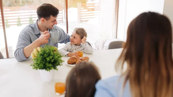 I love you, dad! Handsome young man at home with his little son are having breakfast. Happy Father\'s Day