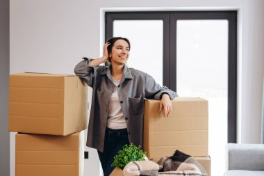 Yeni evinde kendine güvenen genç kadın gülümsüyor..