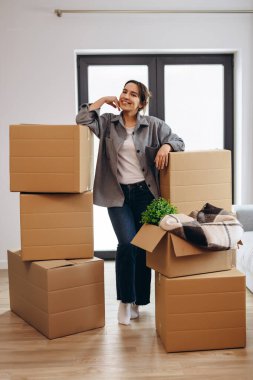 A young girl moved to a new house. Happy is going to spread the boxes.