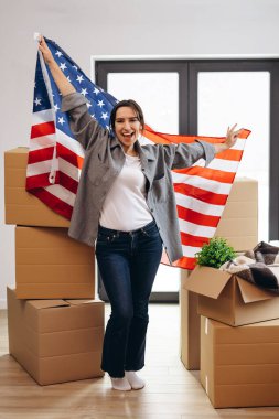 An American woman moved to a new house. Dancing with the US flag.