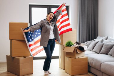 An American woman moved to a new house. Dancing with the US flag.