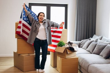 An American woman moved to a new house. Dancing with the US flag.