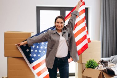 An American woman moved to a new house. Dancing with the US flag.