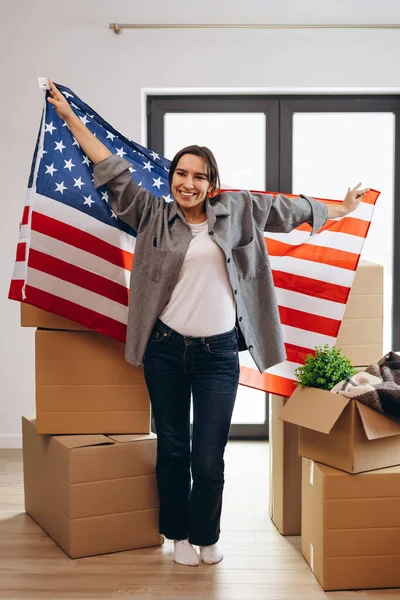An American woman moved to a new house. Dancing with the US flag.